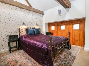 汤顿The Forge的一间卧室配有一张带紫色床罩的床