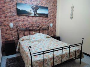 罗萨里奥港Apartment Severo Ochoa的一间卧室设有一张床和砖墙