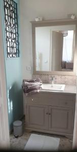Gite mes pt'tis lits maison chaleureuse 4 chambres的一间带水槽和镜子的浴室