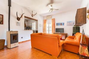圣奥拉利亚德尔卡拉Casa Rural Navalonguilla con piscina operativa的客厅配有橙色家具和壁炉