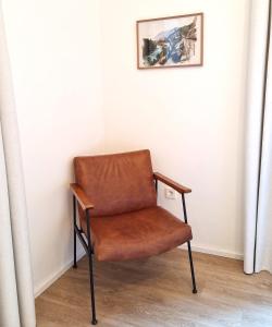 梅拉诺Apartment Emilie with parking historic city center的坐在房间角落的棕色椅子