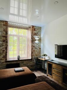 拉克韦雷Vabriku 6 Apartment with sauna的一间卧室配有一张床和一张书桌及电视
