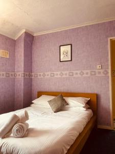 兰卡斯特'Melrose' at stayBOOM的卧室配有白色床和紫色墙壁