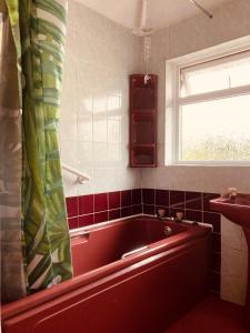 兰卡斯特'Melrose' at stayBOOM的带窗户的浴室内的红色浴缸