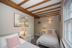 斯托尔河畔希普斯顿Cotswolds period townhouse near Stratford-upon-Avon, central location short walk to pubs, restaurants and shops的一间卧室设有两张床和窗户。