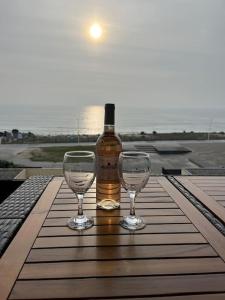 拉卡诺Appartement face à l’Océan的桌子上放有一瓶葡萄酒和两杯酒