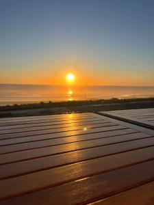 拉卡诺Appartement face à l’Océan的木凳的海上日落