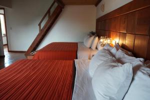 瓦斯卡坎波Torre del Conde的一间卧室配有两张带白色和红色床单的床