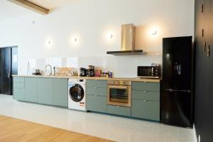巴涅奥莱Loft aux portes de Paris - Parking gratuit的厨房配有蓝色橱柜、洗衣机和烘干机