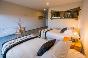纳塔列斯港Hotel Hacienda Dorotea的客房设有三张床、一张桌子和一张桌子