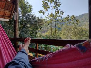 卢米亚Bangalô Boa Ventura的躺在吊床上欣赏山脉景色的人