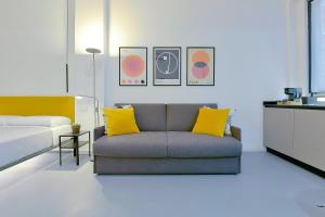 博洛尼亚MONO Apartments的客厅配有沙发和1张床