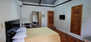 曼塔Cálida suite en Liguiqui - Manta的一间卧室设有一张床和砖墙
