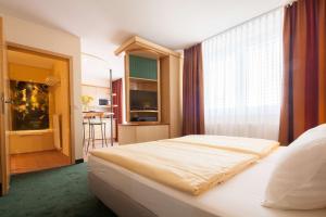 莱比锡莱比锡套房酒店的一间卧室设有一张床和一个大窗户