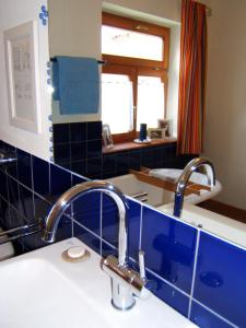 Sontheim客什菲生态旅馆的浴室配有水槽和蓝色瓷砖墙。