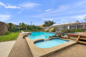 莱克斯恩特伦斯Comfort Inn & Suites Lakes Entrance的一座游泳池,位于一座建筑旁的院子内