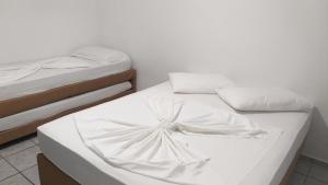 瓜拉图巴Pousada Verdes Mares guaratuba的两张睡床彼此相邻,位于一个房间里