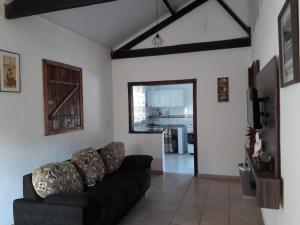 拉夫里尼亚斯Sítio Vista da Serra的一间带黑色沙发的客厅和一间厨房