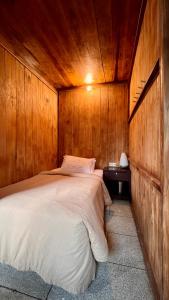 贝都古Chakra Tavern的卧室配有木墙内的一张床