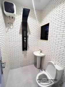 贝宁城Gillant Luxury Homes的浴室位于厕所旁,墙上配有电话