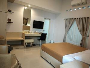 巴东The Sriwijaya Hotel - Halal Hotel的一间卧室配有一张床和一张带电脑的书桌