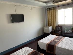 Ban NabôngMekong Hotel的酒店客房设有两张床和一台墙上的电视。