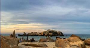 科亚D'Nenas Homestay Kijal的一群人,在海滩上,岩石