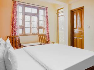 甘托克Hotel Ridgeway的一间卧室设有一张大床和一个窗户。