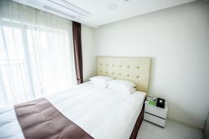 巨济Hotel STAYON的卧室配有白色的床和窗户。