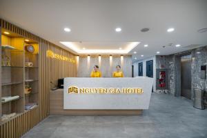 岘港Nguyen Gia Hotel的两人站在大楼的前台