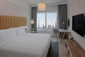 迪拜Staybridge Suites Dubai Financial Centre, an IHG Hotel的一间酒店客房,设有一张大床和一个大窗户
