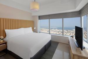 迪拜Staybridge Suites Dubai Financial Centre, an IHG Hotel的卧室设有一张白色大床和大窗户