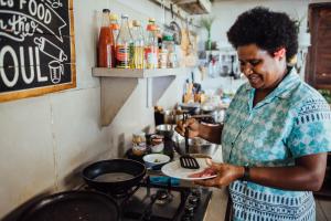 Epule拉梅尔度假酒店的一位在厨房里盘子里准备食物的女人