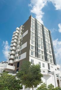 普崇The Signature Serviced Suites Puchong的一座高大的白色建筑,前面有树木