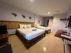 Sungai KolokThebedkolok resort的酒店客房设有两张床和电视。