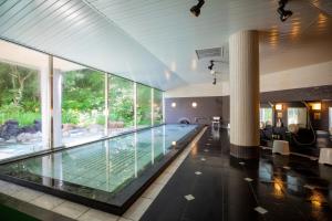 小樽Otaru Asari Classe Hotel的玻璃墙房子内的游泳池