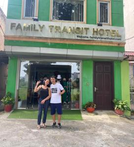 Thach Loi家庭过境酒店的两个人站在绿色建筑前