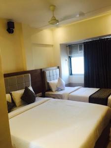 孟买Hotel Sea View - Near Taj Hotel的酒店客房,设有两张床和一张沙发
