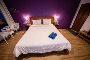 Sungai KolokThebedkolok resort的一间卧室配有一张大床,上面有蓝色的毛巾