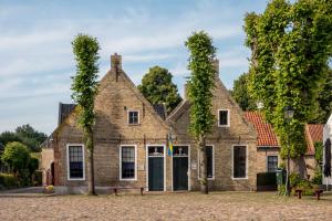WeddeSlaaphutje BuitenWedde Westerwolde的一座常春藤长大的老砖房