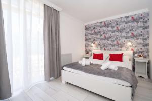 尼赖吉哈佐Villa Rose Garden的卧室配有带红色枕头的白色床