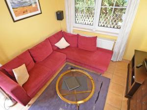 奥斯赛拜-塞林Haus am See - Apt. 01的客厅里一张红色的沙发,配有桌子