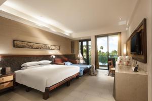 三亚三亚海棠湾万达嘉华度假酒店的酒店客房,配有床和电视