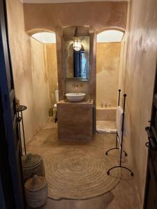 马拉喀什RIAD ENNAFOURA BOUTIQUE HOTEL的一间带水槽、浴缸和镜子的浴室
