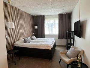 海宁Hotel Sov Godt Herning的卧室配有床、椅子和窗户。