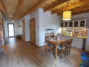 维德米内Zabytkowy dom z 2 sypialniami i 2 ogródkami的厨房以及带木桌和椅子的用餐室。