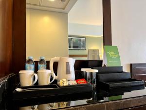 马尼拉Holiday Inn & Suites Makati, an IHG Hotel的装有瓶装水和其他物品的柜台
