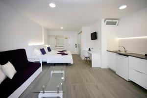 拉克鲁斯Skyview Hotel Tenerife的客厅配有沙发和一张位于房间的床