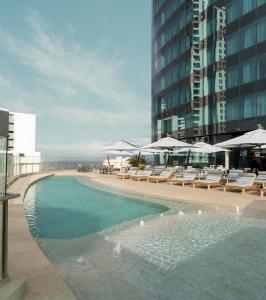 德班Radisson Blu Hotel, Durban Umhlanga的一座大楼内的游泳池,配有椅子和遮阳伞