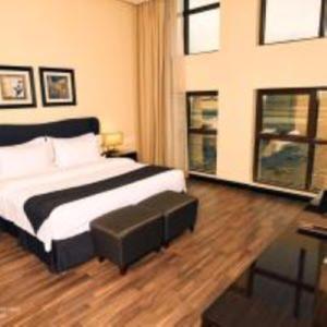 阿可贺巴扎拉大洲酒店的一间卧室配有一张带搁脚凳的床